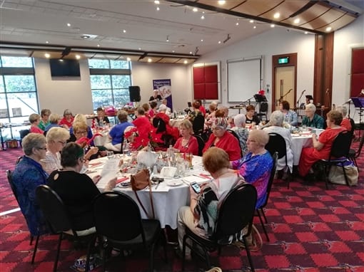 Members seated at round tables for a lunch meeting in a function room