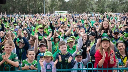 Raiders fans in green cheering at a game